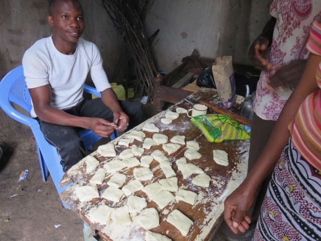 a seated man preparing food at a table