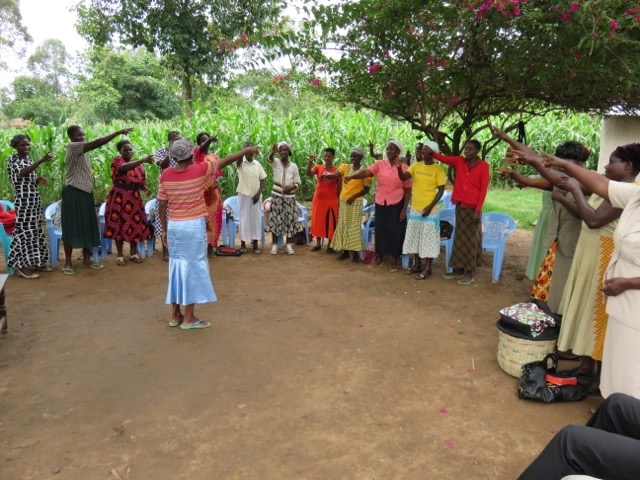 people standing in a circle outside with a woman in the center