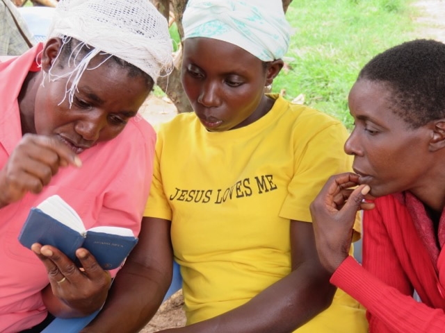 three women reading a Bible together
